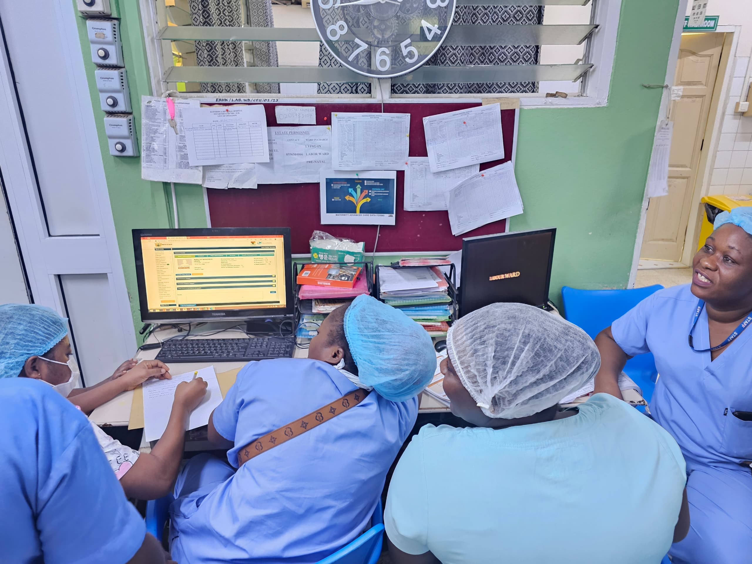 Clinicians reviewing records on a digital health system during a MEBCI visit